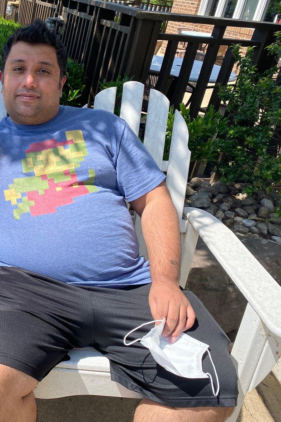 Hammad in May 2021, visibly overweight, sitting in an outdoor chair in a t-shirt