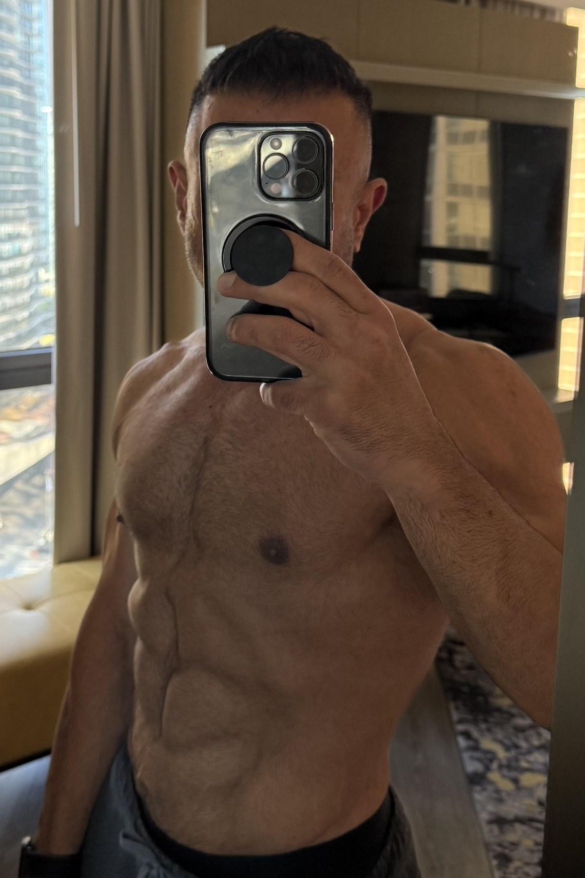 Hammad at 40 in September 2026, shirtless mirror selfie in daylight with clearly defined abs